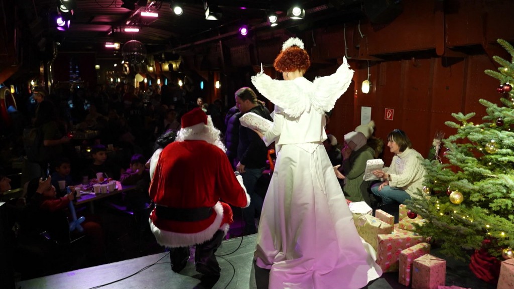 Der Weihnachtsmann und ein Engelchen bei einer Geschenke-Aktion des Kinderschutzbundes