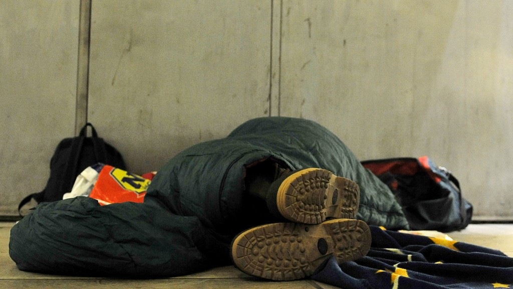 Ein Obdachloser liegt auf dem Boden in einer Unterführung