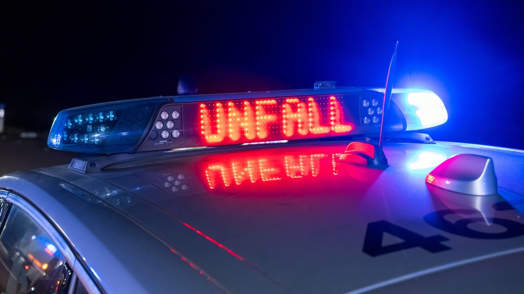 Schild auf einem Polizeiwagen warnt vor einem Unfall