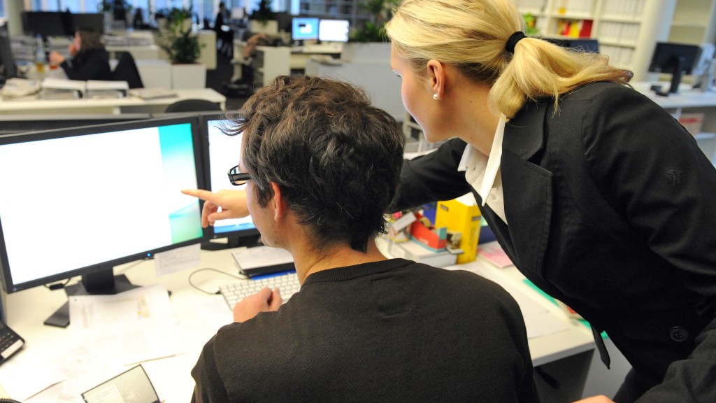 Managerin und Mann vorm Computer.