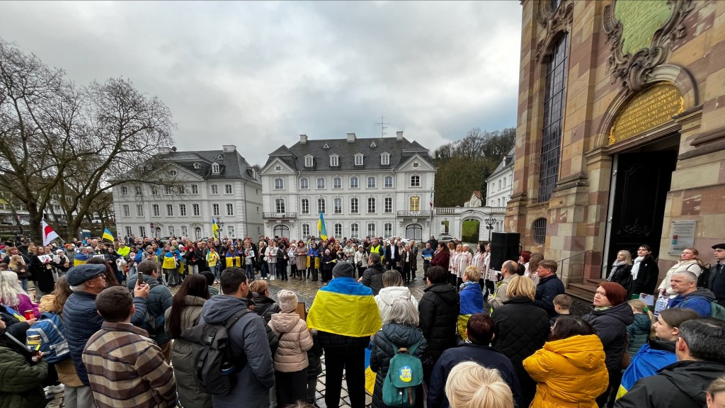 Foto: Teilnehmer einer Gedenkveranstaltung zum vierten Jahrestag des Ukraine-Krieges vor der Ludwigskirche in Saarbrücken.