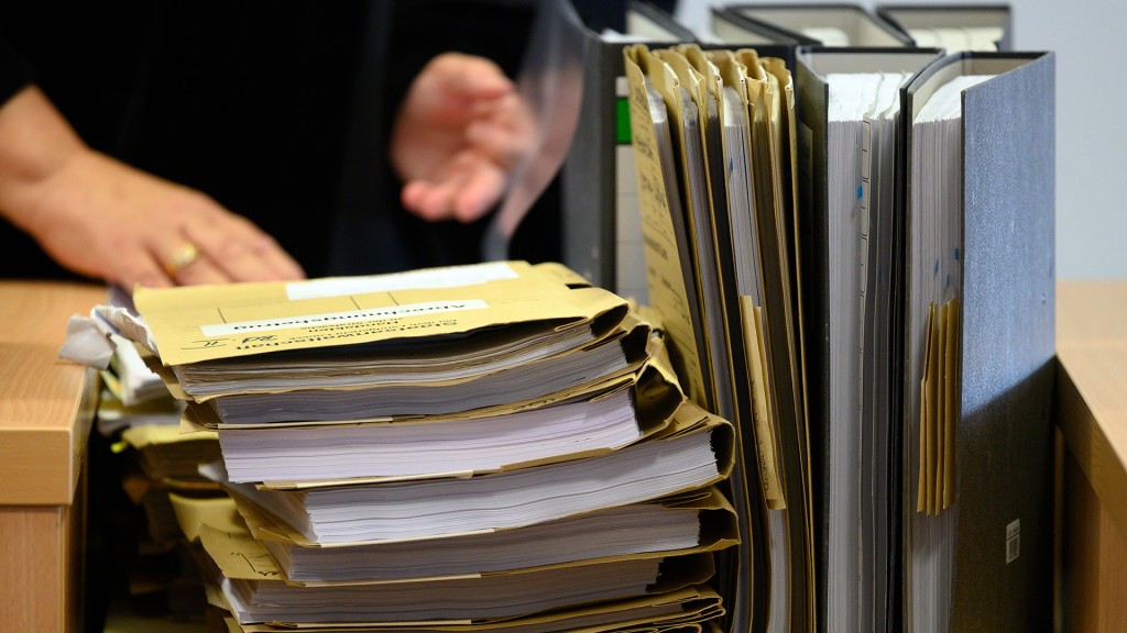 Mehrere gefüllte Aktenmappen und Ordner stehen auf einem Tisch