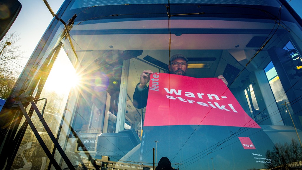 Foto: Ein Streik-Plakat der Gewerkschaft Verdi wird in die Frontscheibe eines Linienbusses gehängt
