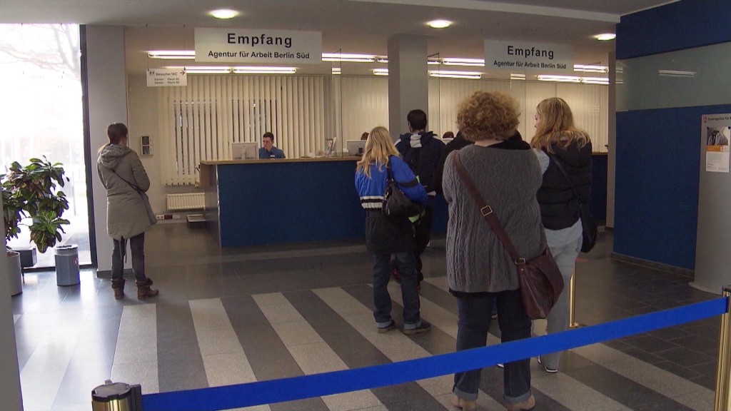 Foto: Menschen stehen in einer Behörde in der Schlange