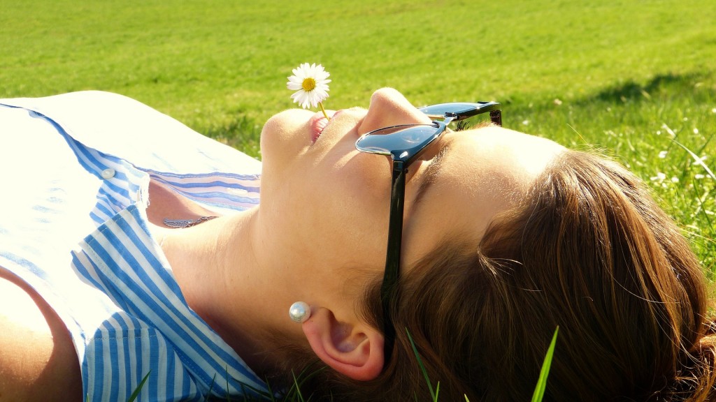 Eine junge Frau liegt auf einer grünen Wiese