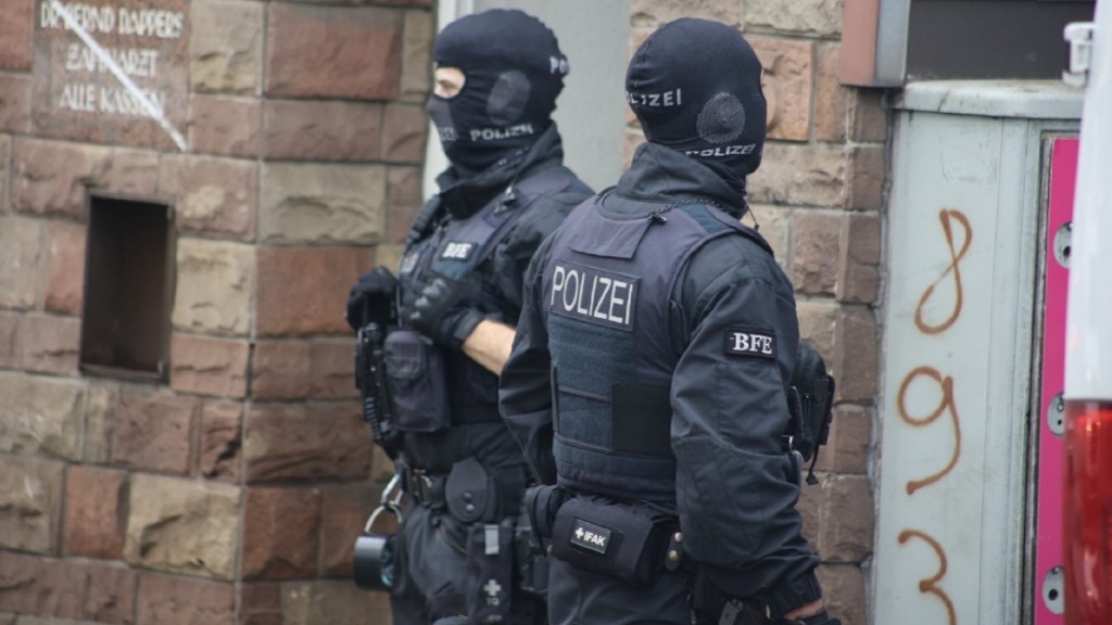 Polizisten mmit vermummten Gesichtern im Rahmen einer Razzia