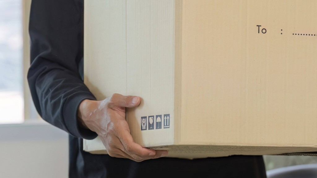 Foto: Ein junger Mann trägt einen Umzugskarton