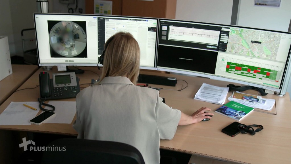 Foto: Eine Frau sitzt vor großen Monitoren
