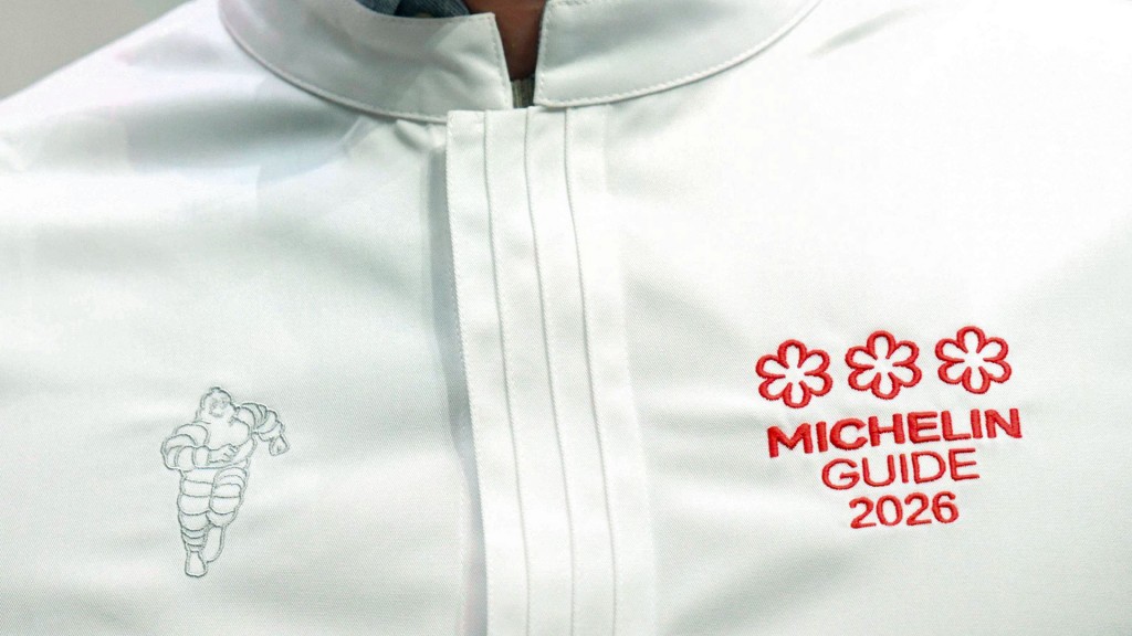 Foto: Ein Koch mit dem Logo des Michelin Guide 2026 und drei Sternen auf seiner Jacke