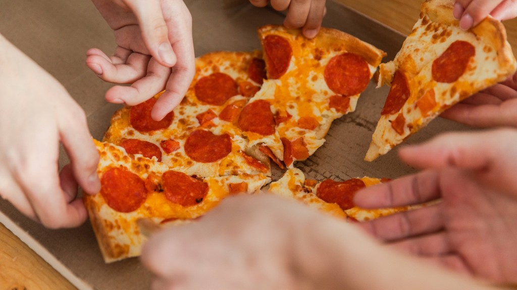 Meherere Menschen greifen nach einem Stück Pizza