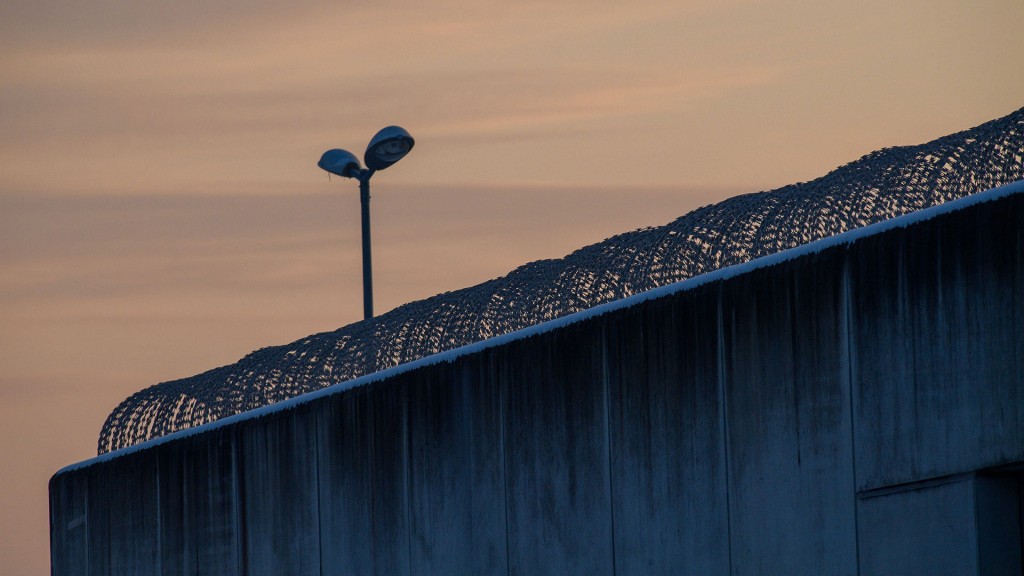 Der Tag bricht über der drahtbewährten Mauer einer Justizvollzugsanstalt an