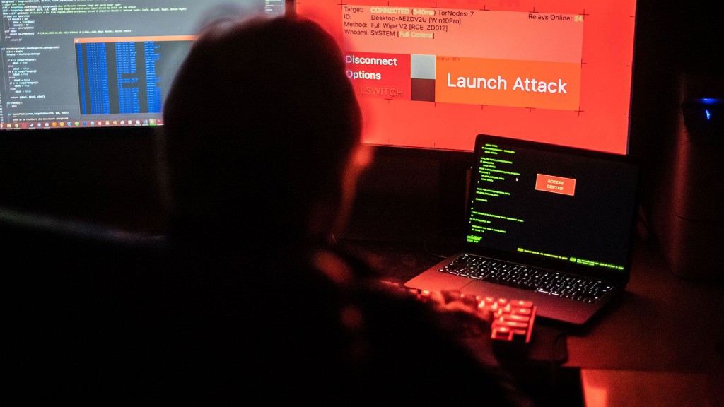 Foto: Illustration: Jemand sitzt während eines Hacker-Angriffs vor einem Computer mit mehreren Bildschirmen