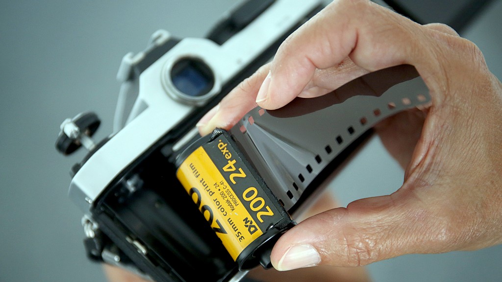 Jemand legt eine Filmrolle in einen Fotoapparat ein