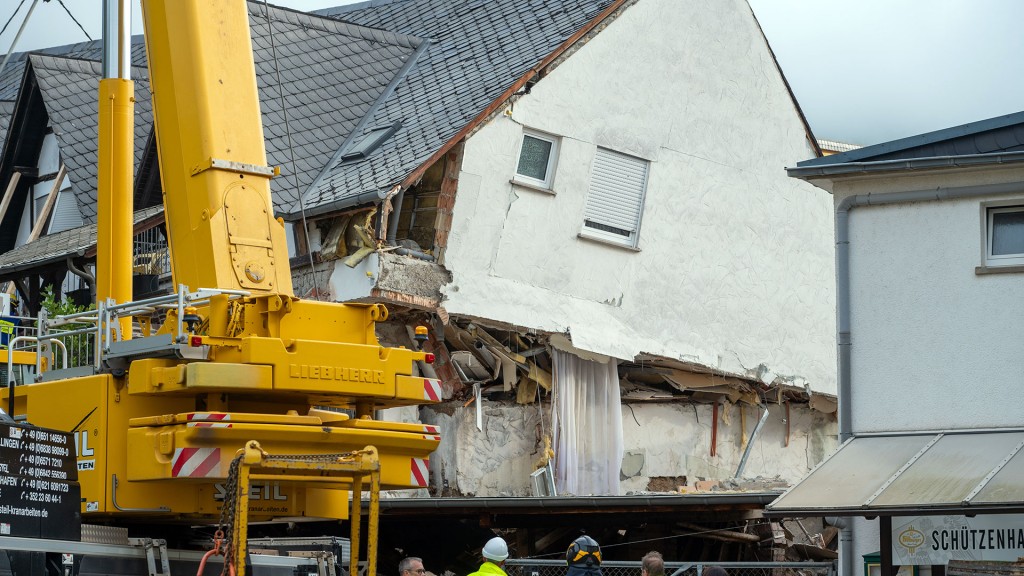 Foto: Ein LKW-Kran steht an einem teilweise eingestürzten Hotel im Rheinland-Pfälzischen Kröv um ein weiteres Absacken zu verhindern