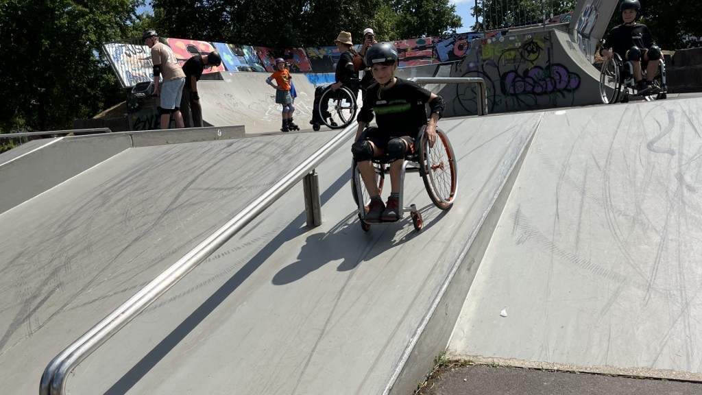 Lasse saust mit Rollstuhl eine Rampe im Skatepark St. Wendel runter.