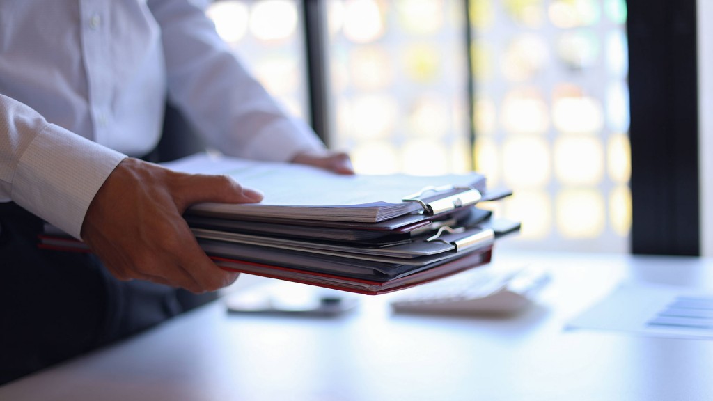 Mann im Büro trägt Stapel von Dokumenten 