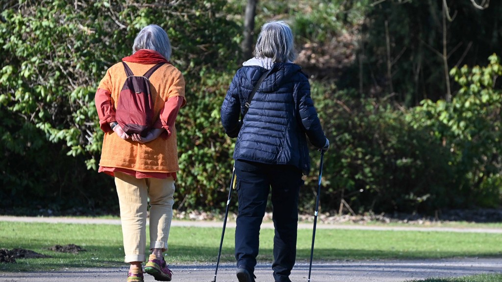 Foto: Zwei Seniorinnen gehen im Park spazieren