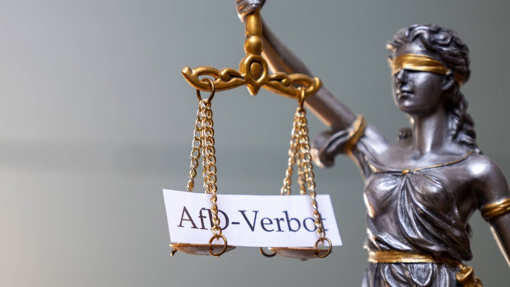 Ein Schild mit der Aufschrift AfD-Verbot liegt auf der Waage einer Justitia-Figur