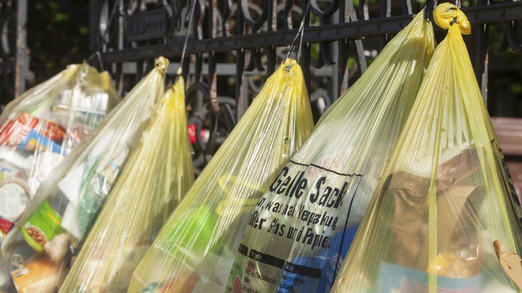 Foto: Gelbe Säcke für Plastikmüll, hängen an Gartenzaun vor einem Hauseingang