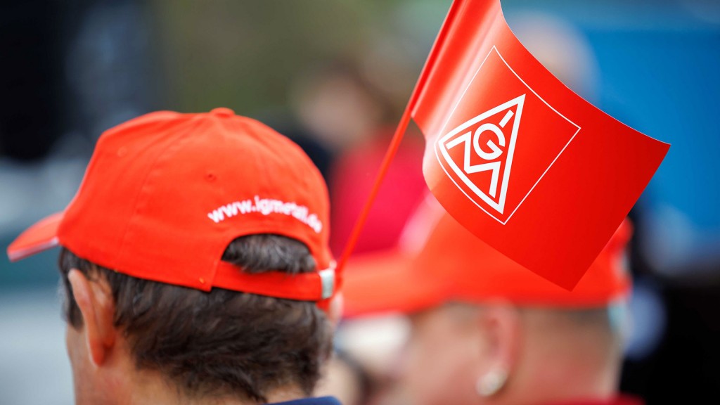 Foto: Menschen mit IG-Metall-Fahnen und -Mützen