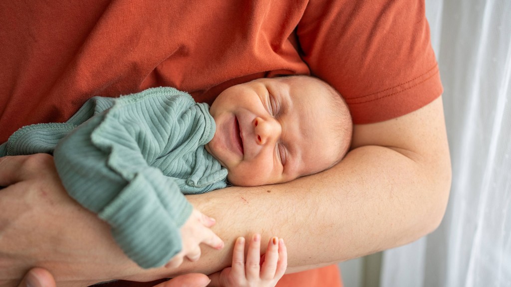 Foto: Ein Person hält ein neugeborenes Kind im Arm