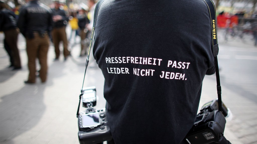 Ein Fotograf trägt ein T-Shirt mit einem Slogan für die Pressefreiheit