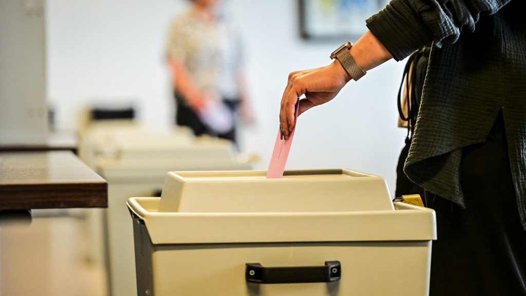 Foto: Eine Person wirft ihren Stimmzettel in eine Wahlurne in einem Wahlbüro