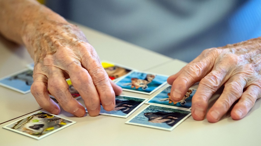 Eine Seniorin legt beim Memory spielen Kartenpaare zusammen