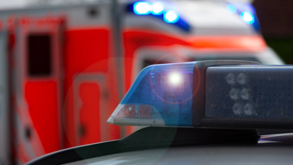Foto: Einsatzfahrzeug, Streifenwagen der Polizei mit Blaulicht, im Hintergrund sieht man einen Rettungswagen