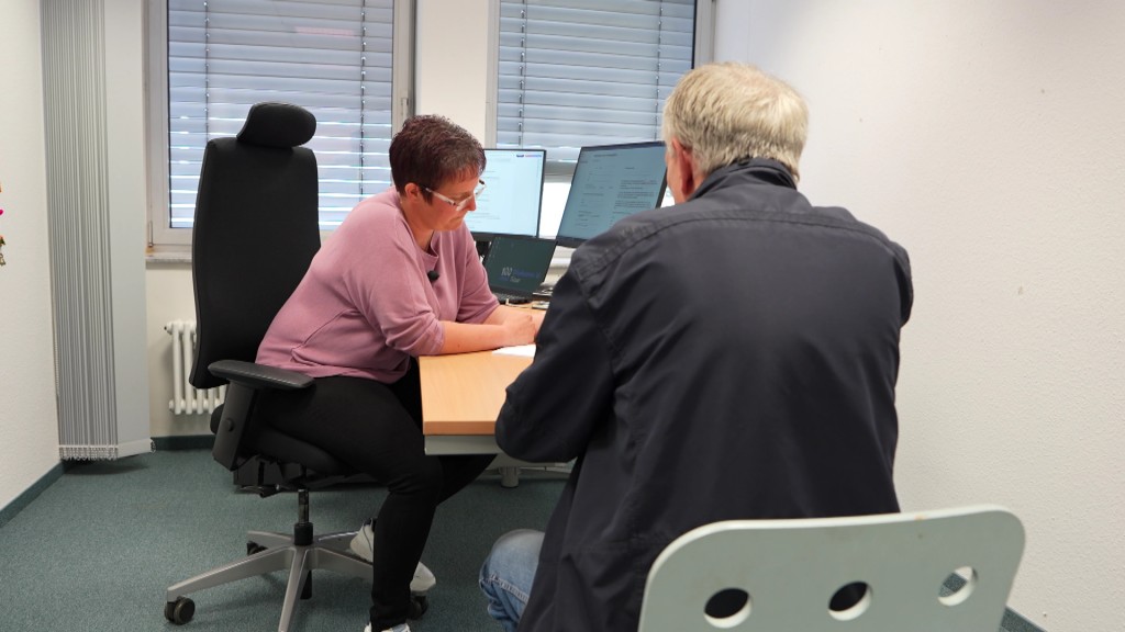 Foto: Zwei Personen sitzen an einem Schreibtisch und besprechen etwas.