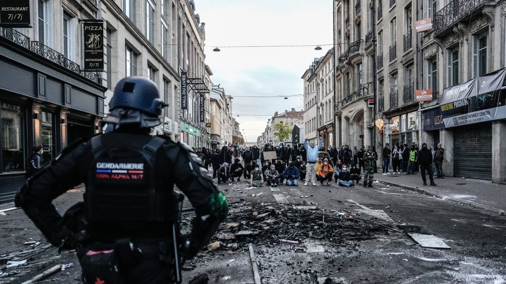 Foto: Französischer Bereitschaftspolizist beobachtet Demonstranten während eines gewaltsamen Protests