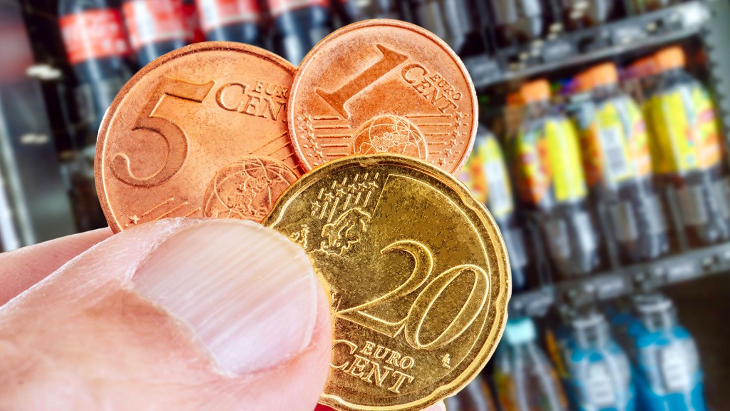 26 Cent in Münzen vor einem Regal mit Softdrinks