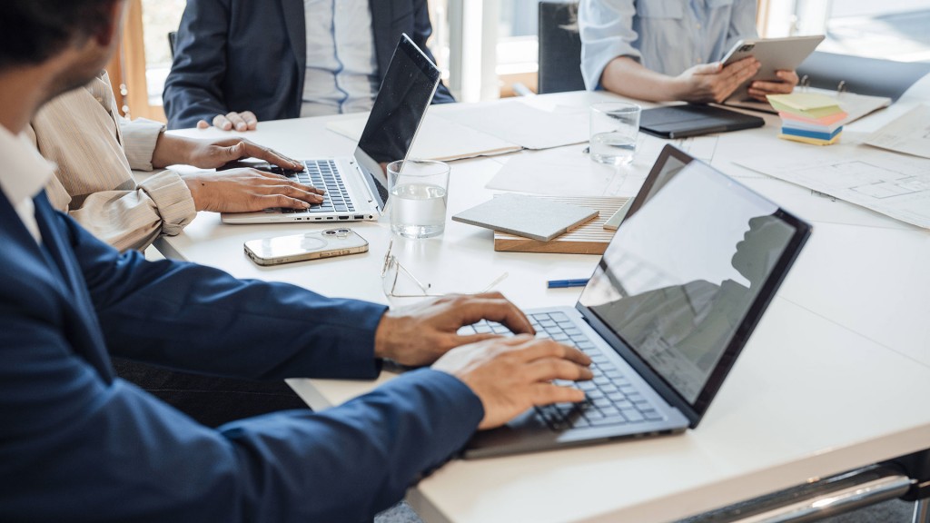Geschäftskollegen tippen während eines Büromeetings auf Laptops