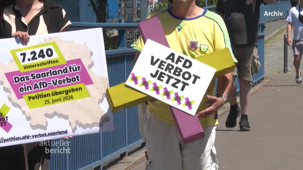 Foto: Personen halten Schilder mit Forderungen