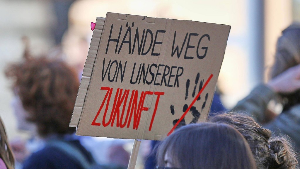 Auf ein Protestschild steht „Hände Weg von unserer Zukunft“
