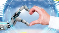 Roboterhand und Menschenhand formen Herz