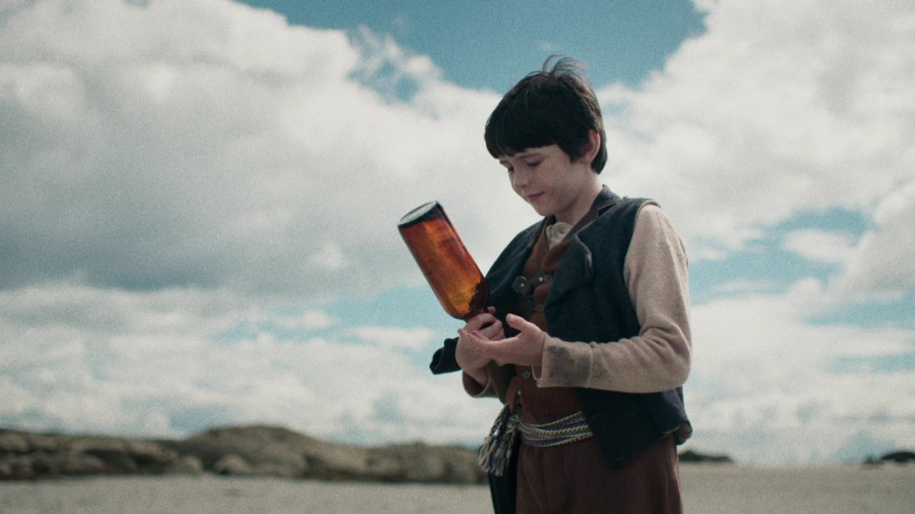 Foto: Ein Junge mit einer Flasche an einem Strand