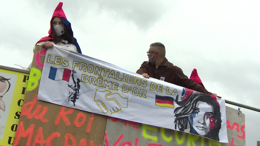 Symbolbild: gemeinsam gegen die Corona-Maßnahmen an der deutsch-französischen Grenze: Protestplakat vom März 2021 (Foto: SR Fernsehen)