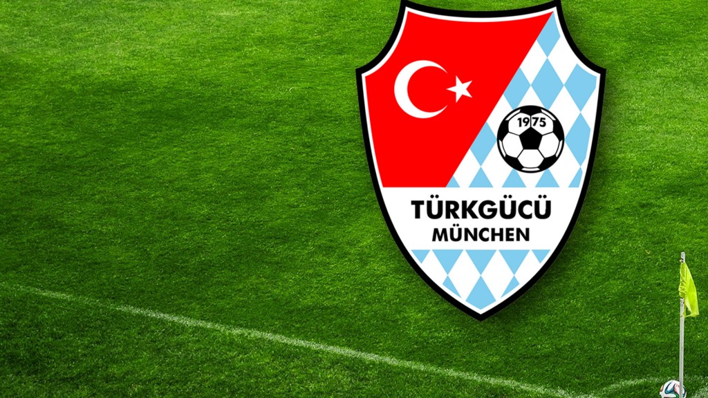 Das Logo des Fußballclubs Türkgücü München vor dem Fußballrasen (Foto: Pixabay)