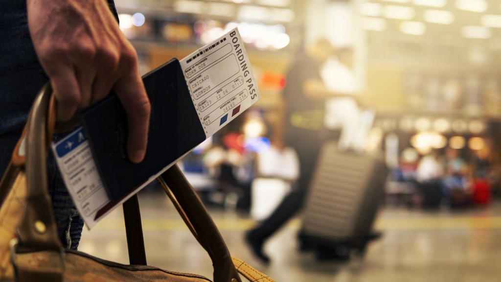 Jemand hält einen Reisetasche mit Reisepass und Boarding-Card in der Hand