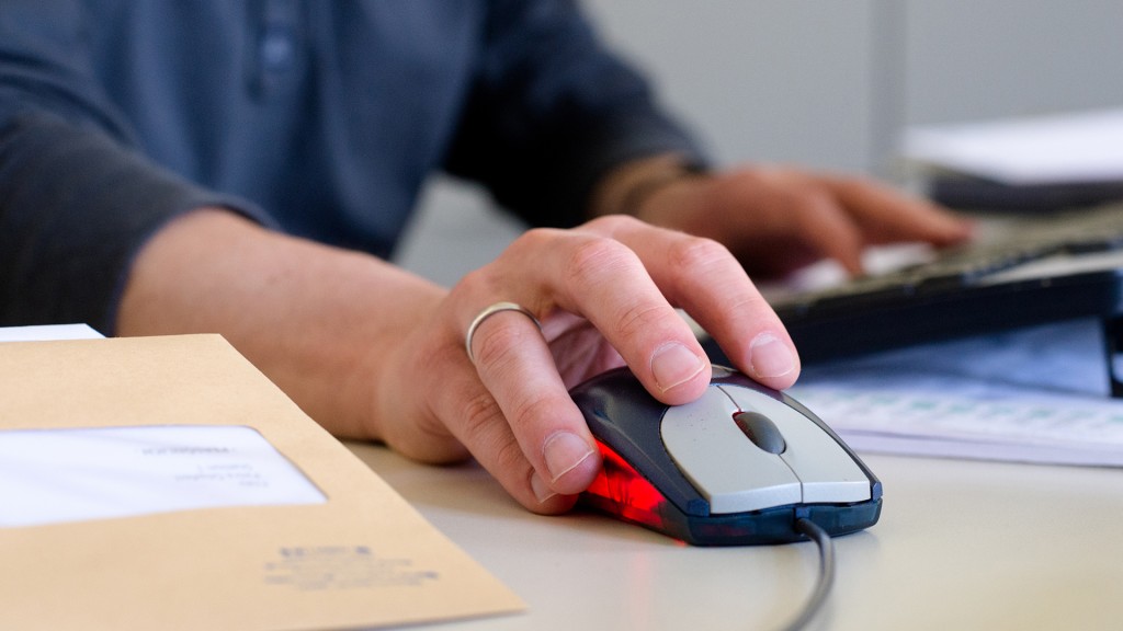 Hand eines jungen Mannes mit Computer Maus und Tastatur.