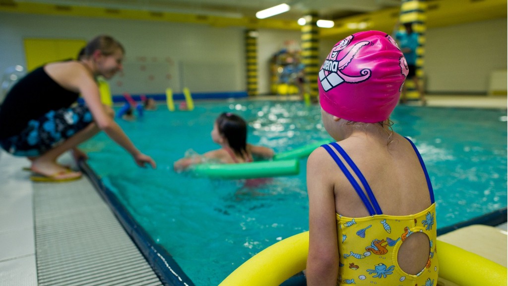 In einer Schwimmhalle nehmen Kinder an einem Schwimmkurs teil.