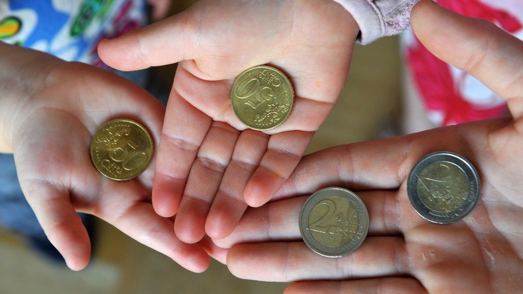 Drei Kinder halten Geldmünzen in den Händen. 