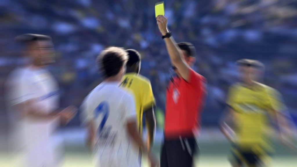 Schiedsrichter zeigt einem Fußballspieler die gelbe Karte