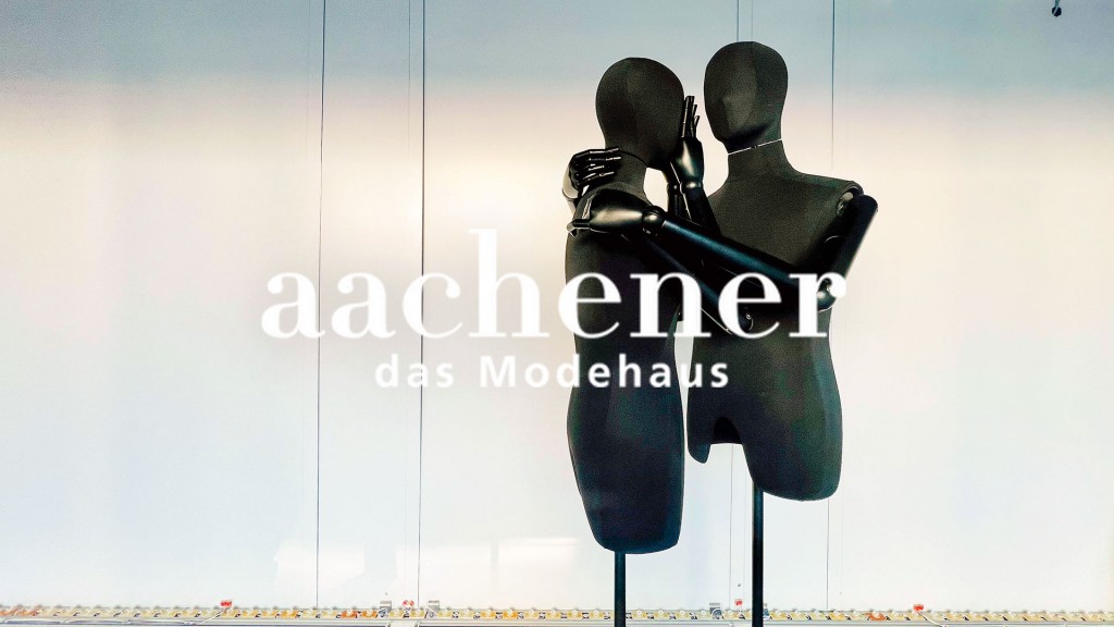 Bildmontage: Zwei Schaufensterpuppen stehen trauernd hinter dem Logo des „Aachener“ Modehauses in einem Schaufenster der ehemaligen Galeria-Karstadt Kaufhof Filiale in der Bahnhofstraße in Saarbrücken