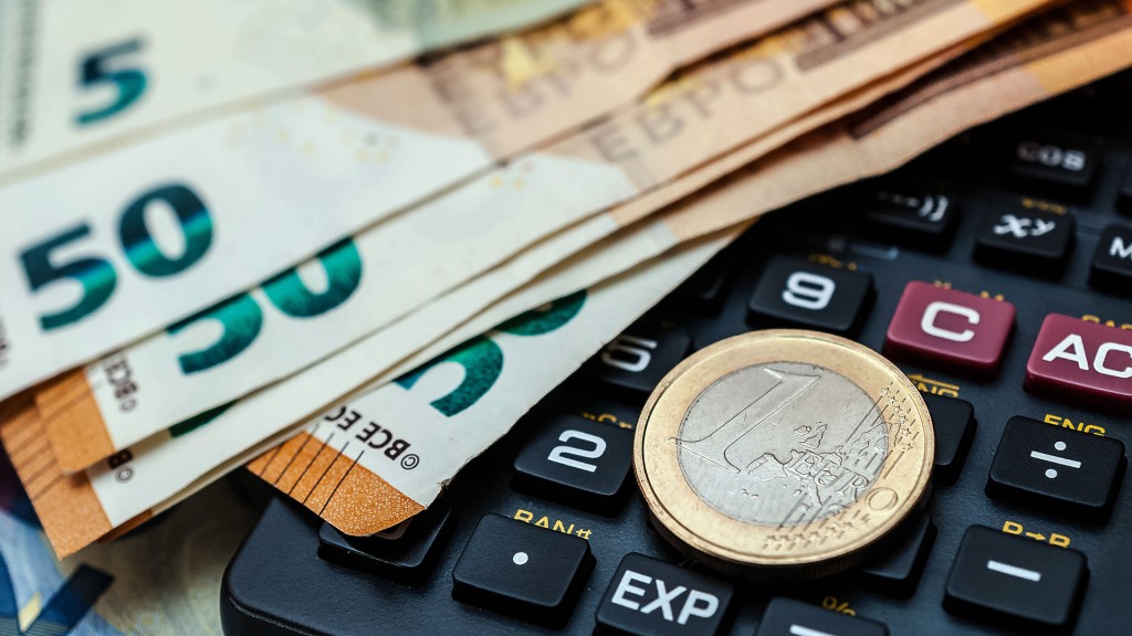 Foto: Geldscheine und eine Münze liegen auf einem Taschenrechner