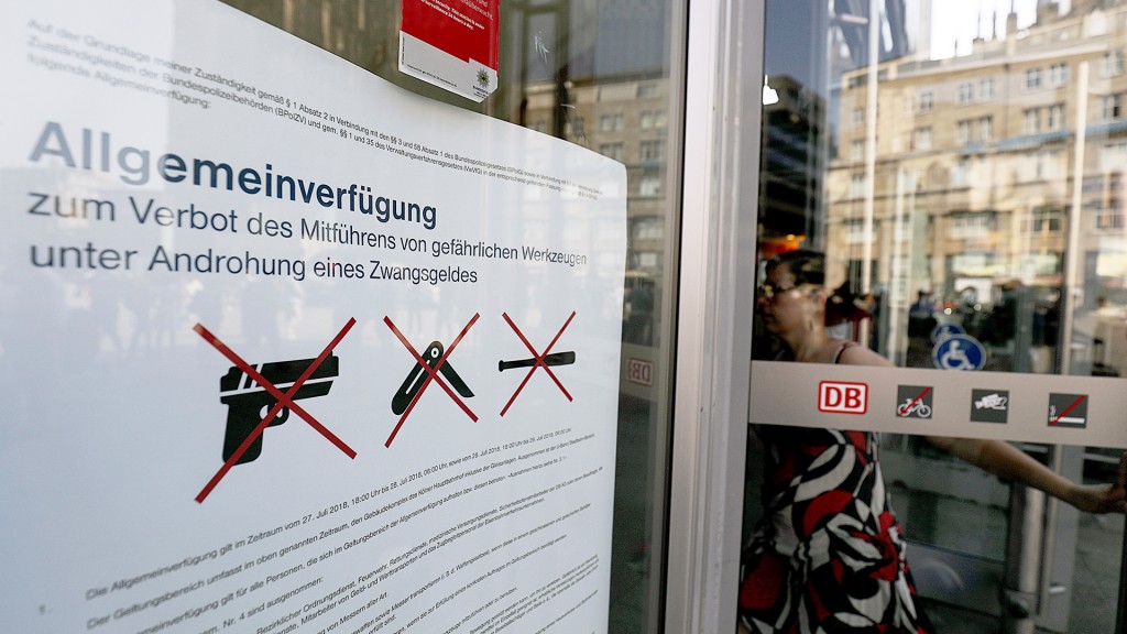 Ein Plakat hängt am Eingang des Hauptbahnhofes und informiert über das Waffenverbot.