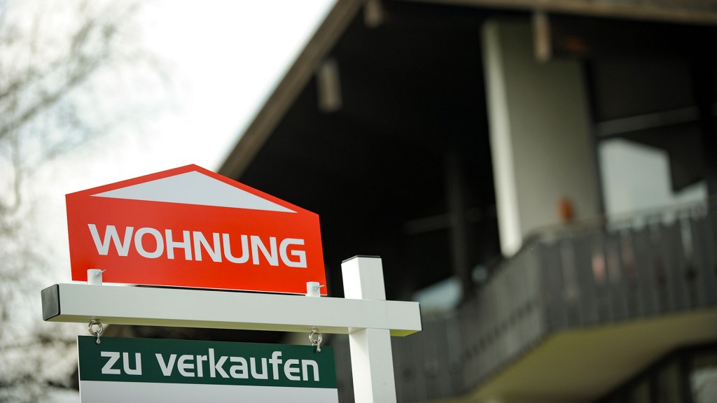 Ein Schild mit der Aufschrift «Wohnung zu verkaufen» steht vor einem Haus