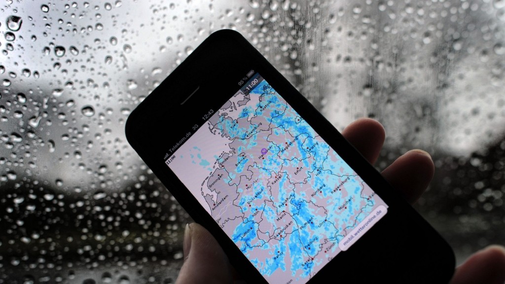 Auf einem Smartphone ist auf einer Wetter-App Regen über fast ganz Deutschland zu sehen. 