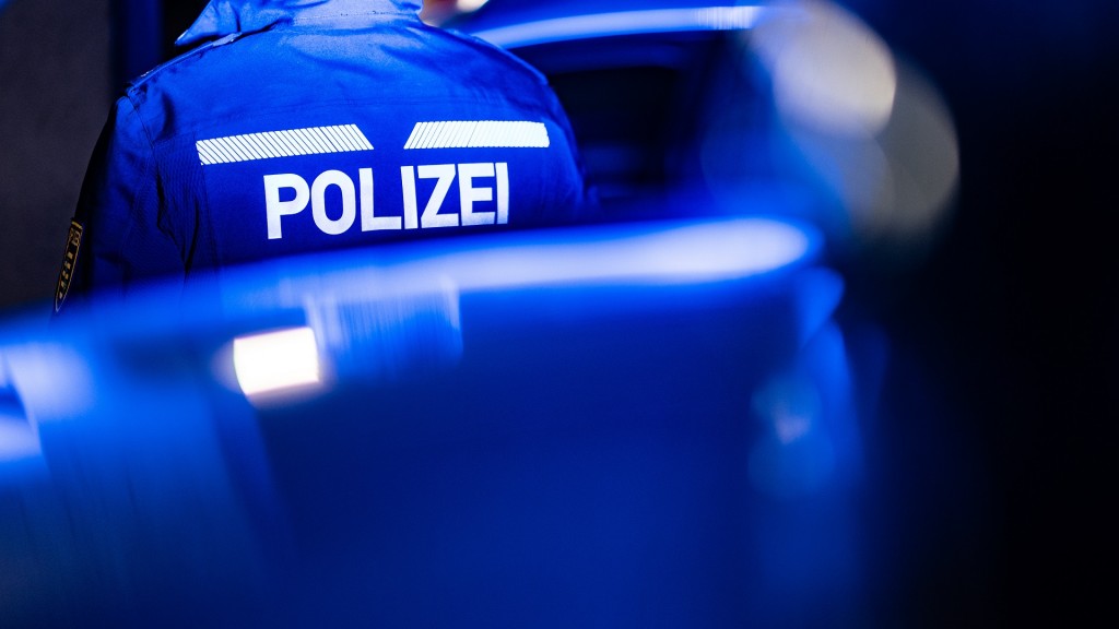 Ein Polizist steht neben einem Polizeiauto